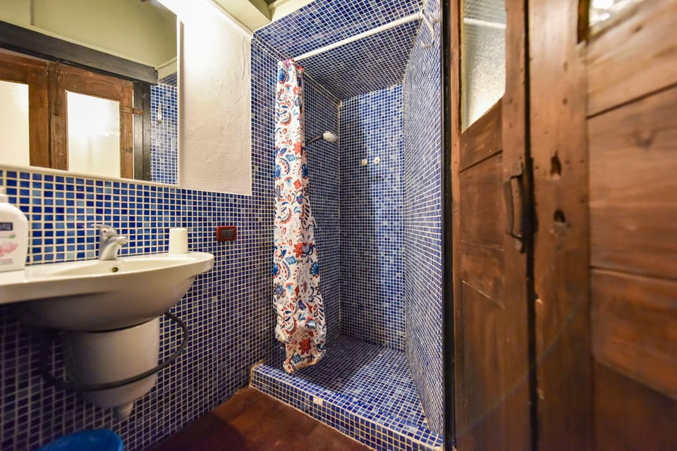 Bagno a mosaico blu con doccia in muratura