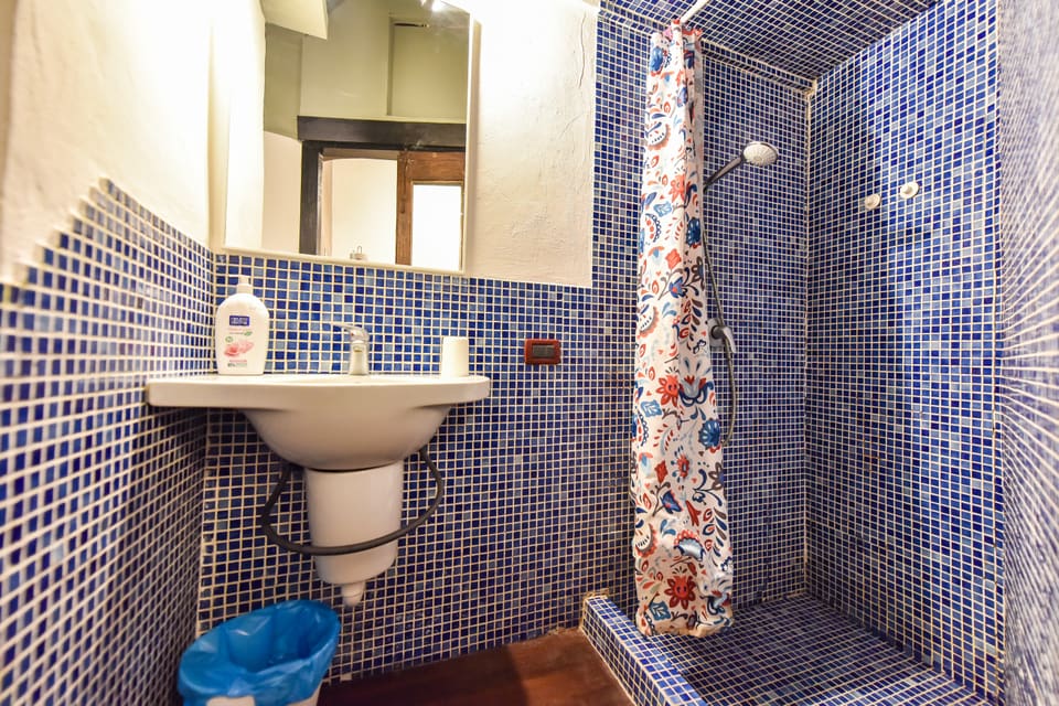Lavabo con specchio e doccia a mosaico blu