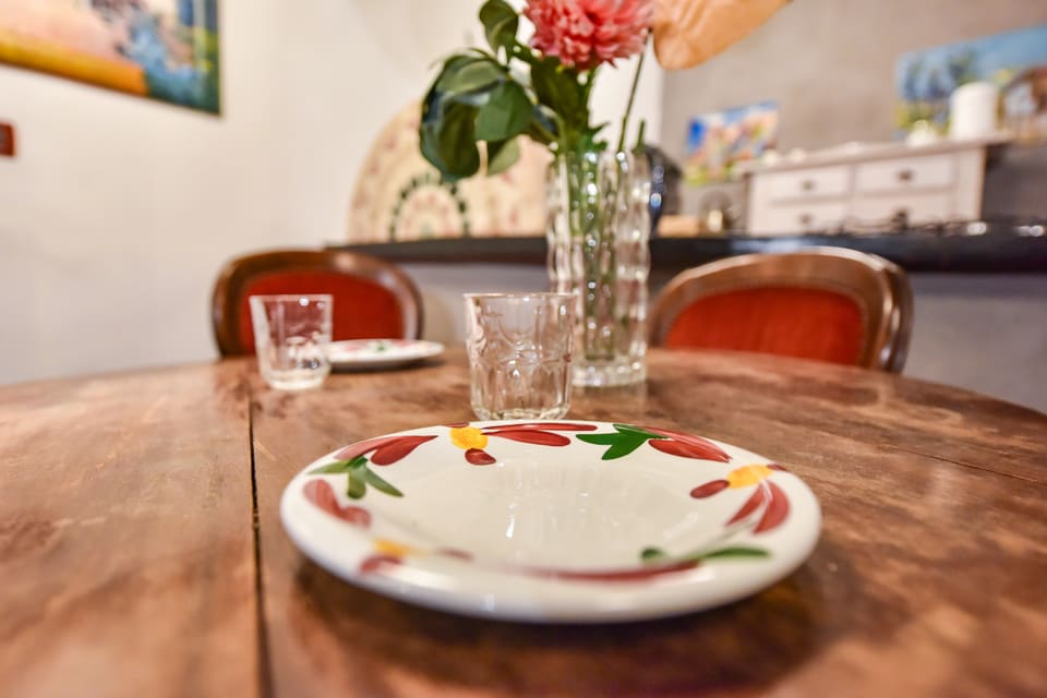Tavola apparecchiata con piatti dipinti a mano e fiori